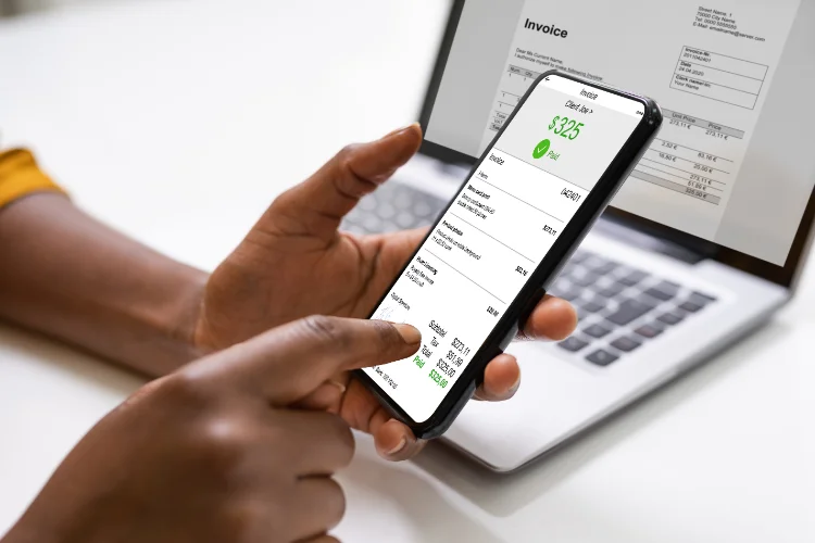 Xero simplifies supplier payment management through a person holding a smartphone with an invoice on it. - JacRox