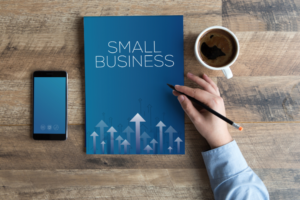 A person holding a small business notebook and a phone demonstrating the convenience of Xero Accounting.