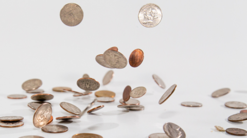 A pile of coins on a white surface for Xero Training. - JacRox