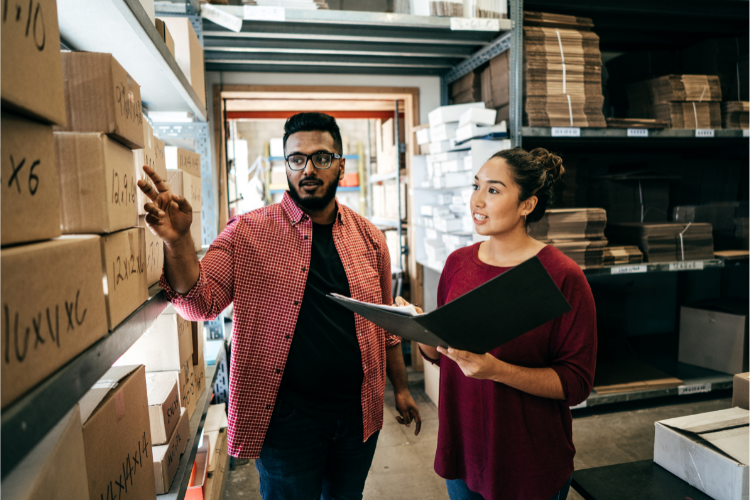 Small businesses facing skills gaps have two people looking at boxes in a warehouse.