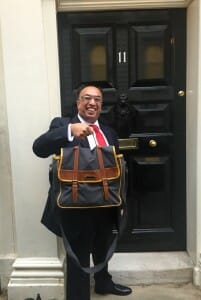A man holding a briefcase in front of a door seeking Xero's assistance with new Dividend Tax.