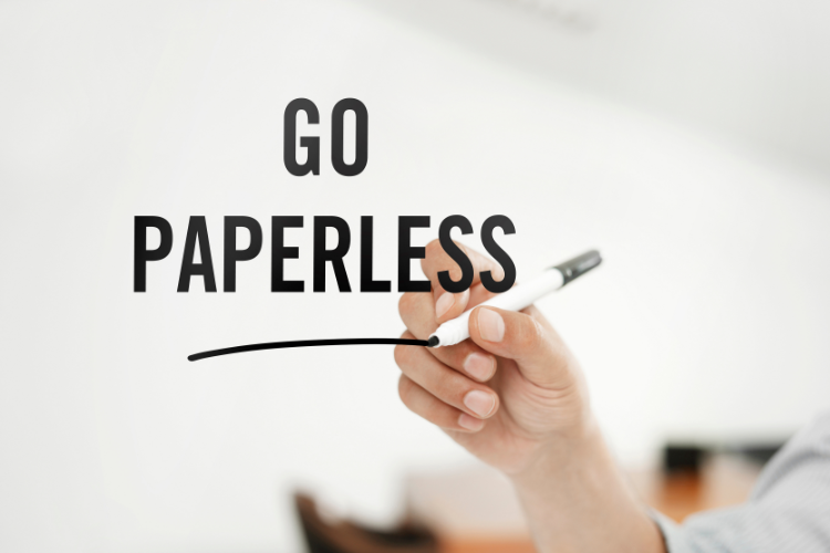 A man writing the word "go paperless" on a whiteboard while utilizing Xero business bookkeeping software.