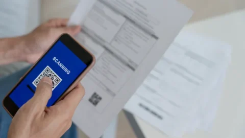 A person using a smartphone for managing supplier invoices. - JacRox