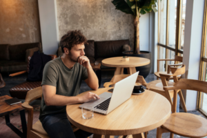 A freelancer working on a laptop in a coffee shop.