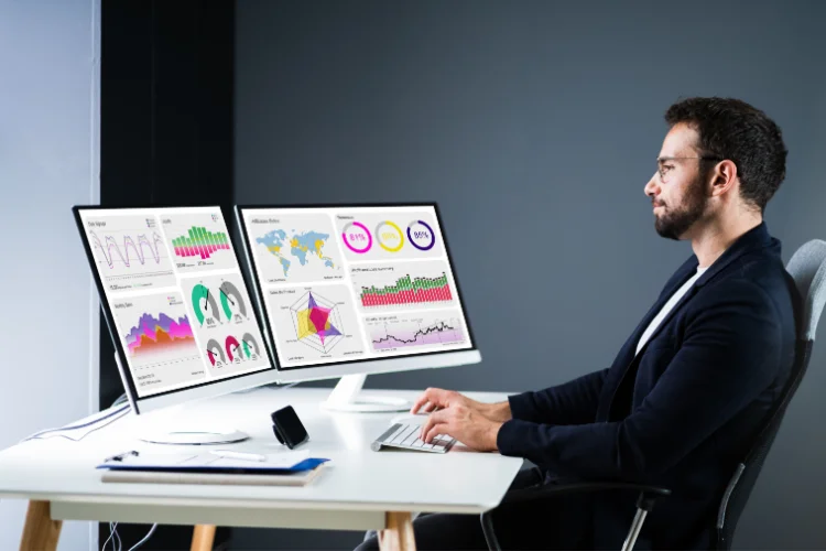 Businessperson sitting at a desk working at a computer - JacRox